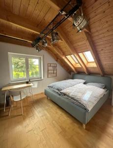 Schlafzimmer mit einem Bett, einem Schreibtisch und Fenstern in der Unterkunft Panorama-Suite Birkenbeul in Birkenbeul