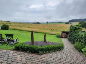 a garden with a bench and flowers in a field at Panorama-Suite Birkenbeul in Birkenbeul