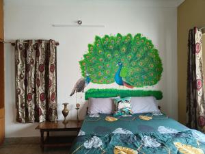a bedroom with a peacock on the wall at Tusker Tribe in Mysore