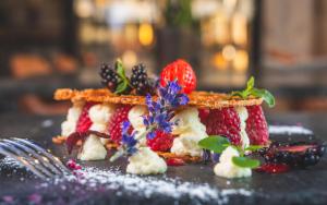 a stack of waffles with strawberries and berries on a table at Stockinggut by AvenidA Hotel & Residences in Leogang