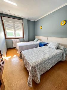 a bedroom with two beds and a window at Casa Manola in Teo
