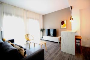 a living room with a couch and a tv at Del Parque Flats Urban Relax in Málaga