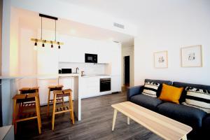 sala de estar con sofá y cocina en Del Parque Flats Urban Relax, en Málaga