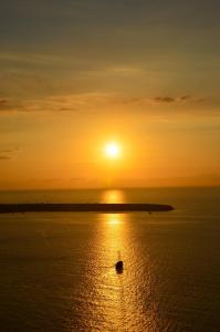 a boat in the ocean at sunset at The Wild by Interni in Kalafatis