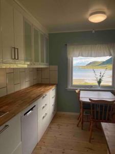 a kitchen with a table and a view of the ocean at Charming house in fjord Lofoten 