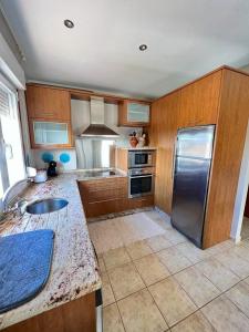 uma cozinha com armários de madeira e um frigorífico de aço inoxidável em Casa Manola em Teo