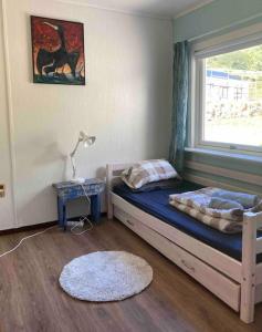 a bedroom with a bed with a window and a rug at Charming house in fjord Lofoten 