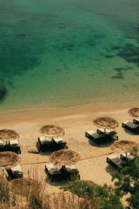 un grupo de sombrillas y sillas en una playa en The Wild by Interni, en Kalafatis