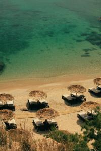 a group of umbrellas and chairs on a beach at The Wild by Interni in Kalafatis