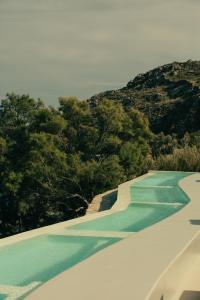 a swimming pool with a green golf course at The Wild by Interni in Kalafatis