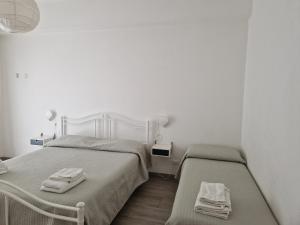 2 letti in una piccola camera con pareti bianche di Between Pisa and 5 Terre a Marina di Carrara