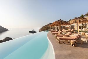 a row of chairs and umbrellas at a resort at The Wild by Interni in Kalafatis