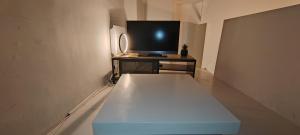 eine weiße Bank in einem Zimmer mit einem TV in der Unterkunft Palais des Rois d'Aragon in Montpellier