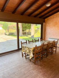ein Esszimmer mit einem Tisch und Holzstühlen in der Unterkunft Casa Manola in Teo