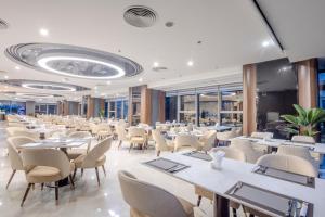 Un gran comedor con mesas y sillas. en Annova Nha Trang Hotel, en Nha Trang
