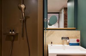 a bathroom with a shower and a sink and a mirror at Hotel Indigo Dresden - Wettiner Platz, an IHG Hotel in Dresden