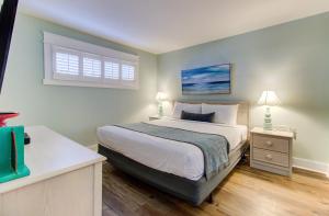 a bedroom with a large bed and a window at 0606 Endless Summer by Atlantic Towers in Carolina Beach