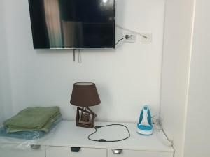 a table with a lamp and a tv on a wall at Mihail apartament in Năvodari