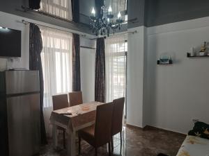 a dining room with a table and chairs and windows at Mihail apartament in Năvodari