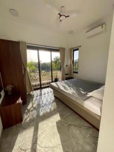 een slaapkamer met een groot bed en grote ramen bij Redhomex Dolce Vita Villa in Lonavala