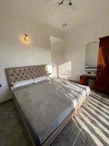 een groot bed in een kamer met een flatscreen-tv bij Redhomex Dolce Vita Villa in Lonavala