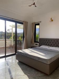 een slaapkamer met een groot bed en een balkon bij Redhomex Dolce Vita Villa in Lonavala