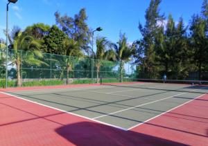 Una cancha de tenis con dos personas jugando en ella en Seaview Timurbay Kuantan, en Kuantan