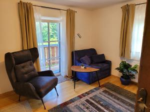 a living room with a couch and a chair and a table at Appartemens Marianne in Grossgmain