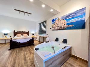 聖喬瓦尼拉蓬特的住宿－Carrubba's luxury home，卧室配有大浴缸和床