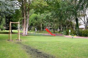 un parque con un parque infantil con un tobogán rojo en Maison avec terrasses à 300m de la mer Juno Beach, en Bernières-sur-Mer