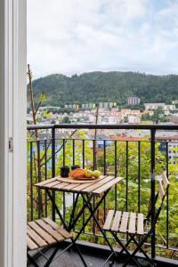 una mesa y sillas en un balcón con vistas en Lys & luksuriøs leilighet midt i Bergen sentrum! en Bergen