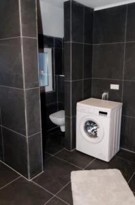 a bathroom with a washing machine and a toilet at Wohnung Bruchsal in Bruchsal