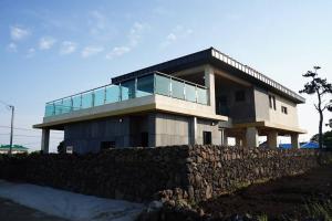 a house with a glass balcony on top of it at Mirine Jeju in Jeju