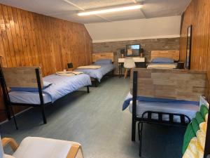 Cette chambre comprend 3 lits, une table et des chaises. dans l'établissement Black Mountain Family Room, à Velindre