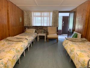 Cette chambre comprend trois lits et une chaise. dans l'établissement Black Mountain Family Room, à Velindre