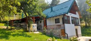 a small white house with a blue roof at Aura natura in Visoko +17 photos