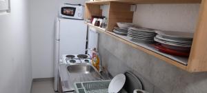 a kitchen with a sink and a shelf with dishes at Aura natura in Visoko