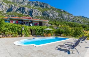 a house with a swimming pool in front of a mountain at Family House Gata in Gata