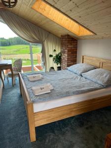 a bedroom with a large bed with a large window at Czaple Resort in Stare Czaple