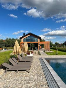 a group of chairs and umbrellas next to a pool at Czaple Resort in Stare Czaple