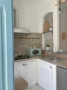 a kitchen with a sink and a stove top oven at La residenza del sindaco in Carloforte