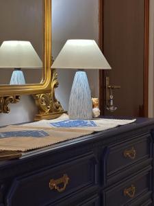 uma lâmpada em cima de uma cómoda com um espelho em La residenza del sindaco em Carloforte
