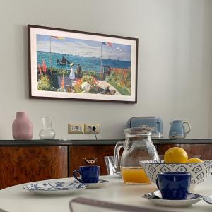 einen Tisch mit einem Krug Orangensaft und einem Gemälde in der Unterkunft La residenza del sindaco in Carloforte
