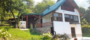 a white house with a blue roof at Aura natura in Visoko