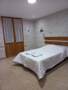 a bedroom with a bed with two towels on it at Quinta Alpaca in Arequipa