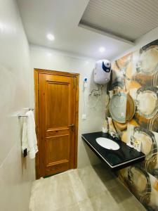 a bathroom with a sink and a wooden door at Luxury Apartment in Bahria Town, Lahore in Lahore