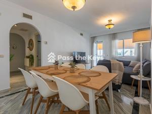 ein Esszimmer und ein Wohnzimmer mit einem Holztisch und Stühlen in der Unterkunft Pass the Keys Apt family friendly in Marbella