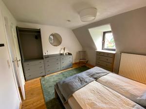 a bedroom with a bed and a dresser and a mirror at Haus No. 16 in Ratzeburg