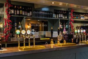 a bar with a bunch of bottles of wine at The George at Backwell in Nailsea