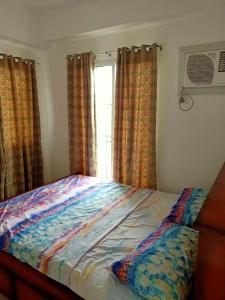 een bed in een slaapkamer met een raam bij Cebu City Apple One Banawa Heights in Cebu City